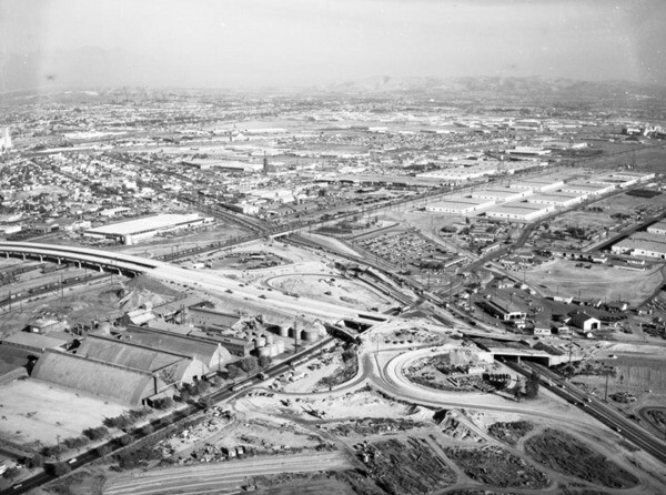 Aerial black and white photograph of I-710 freeway construction cutting through East Los Angeles communities, circa 1960s